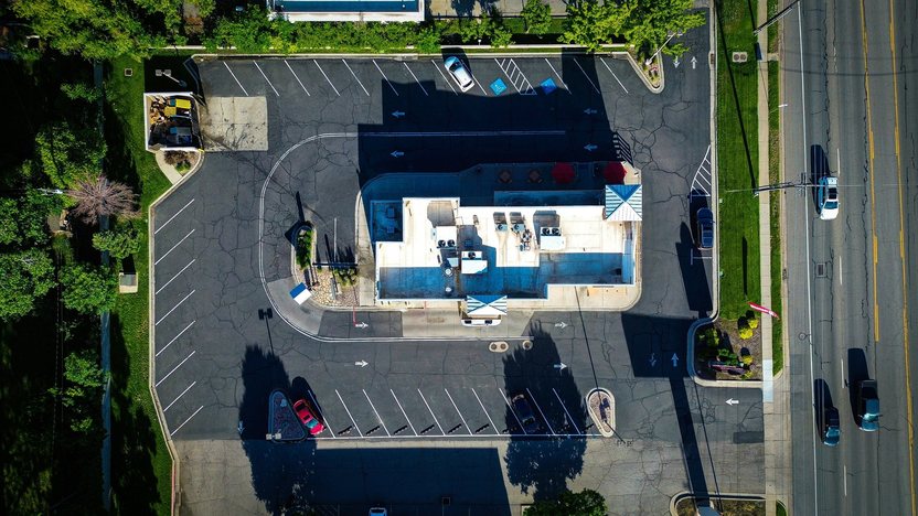 An overhead aerial view of a drive-through restaurant and its parking lot