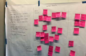 A journey map built from pink sticky notes on butcher paper, tracing success criteria and pain points