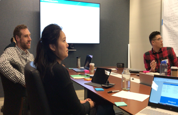 A working session around a conference table with the concept projected on screen